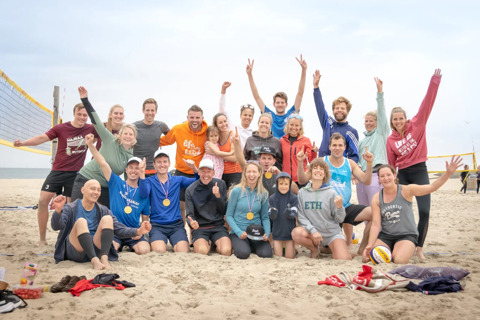 Juichende groep collega's op het strand na een teamactiviteit