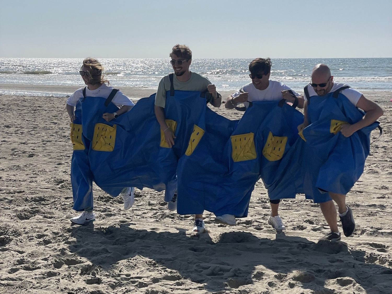 Collega's racen samen in een groot zakloopspel op het strand