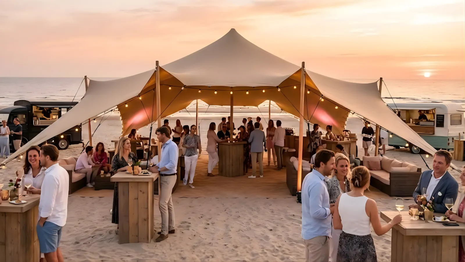 Bedrijfsevent op het strand bij zonsondergang met stretchtent, bar, lounge en foodtrucks
